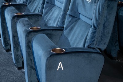Salle de cinéma avec des rangées de fauteuils rouges et un écran affichant ’Salle 1, 318 fauteuils’.