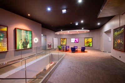Salle de cinéma avec des rangées de fauteuils rouges et un écran affichant ’Salle 1, 318 fauteuils’.