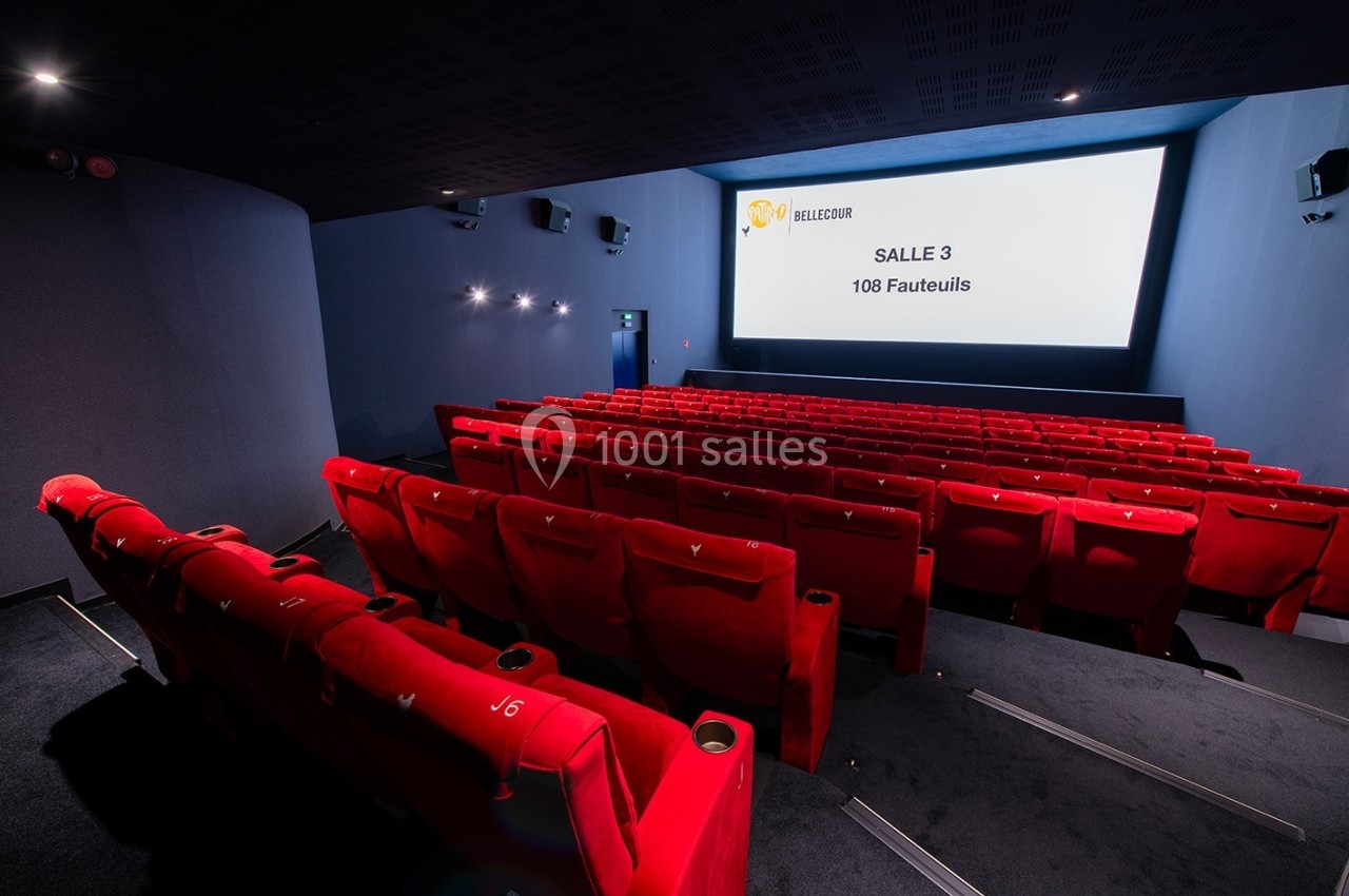 Salle de cinéma moderne avec des rangées de fauteuils rouges et un écran affichant ’Salle 3 - 108 Fauteuils’.