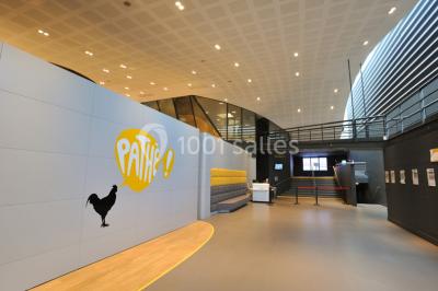 Hall d'entrée d'un cinéma Pathé avec un comptoir d'accueil, des sièges et un décor moderne.