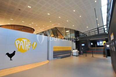 Hall d'entrée d'un cinéma Pathé avec un comptoir d'accueil, des sièges et un décor moderne.