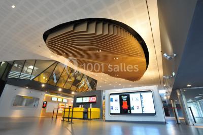 Hall d'entrée d'un cinéma Pathé avec un comptoir d'accueil, des sièges et un décor moderne.