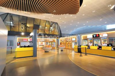 Hall d'entrée d'un cinéma Pathé avec un comptoir d'accueil, des sièges et un décor moderne.