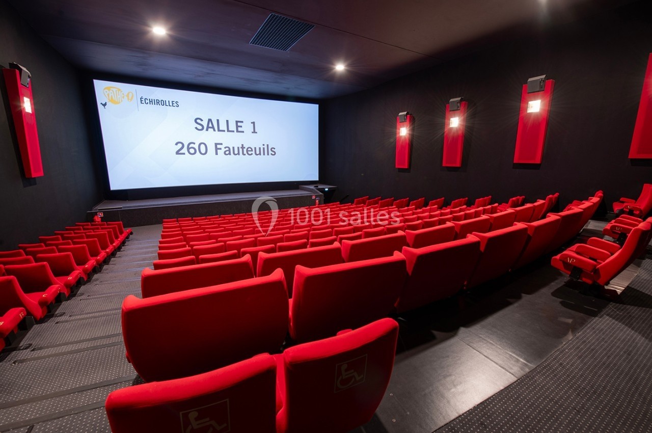 Salle de cinéma moderne avec des rangées de fauteuils rouges et un écran affichant ’Salle 1, 260 fauteuils’.