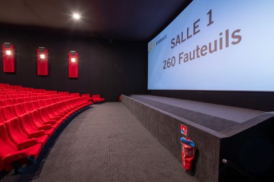 Couloir moderne avec éclairage tamisé, sièges incurvés, distributeurs automatiques et écrans muraux.