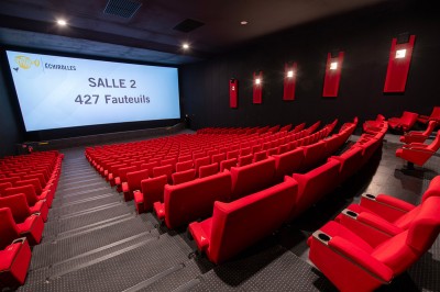 Couloir moderne avec éclairage tamisé, sièges incurvés, distributeurs automatiques et écrans muraux.