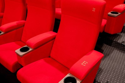 Couloir moderne avec éclairage tamisé, sièges incurvés, distributeurs automatiques et écrans muraux.