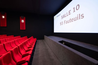 Couloir moderne avec éclairage tamisé, sièges incurvés, distributeurs automatiques et écrans muraux.