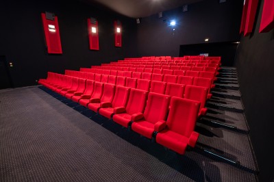 Couloir moderne avec éclairage tamisé, sièges incurvés, distributeurs automatiques et écrans muraux.