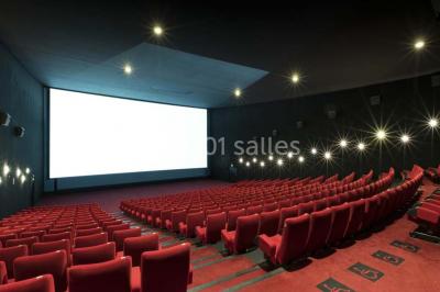 Façade d'un cinéma Pathé avec affiches de films en vitrine, sous un ciel bleu clair.