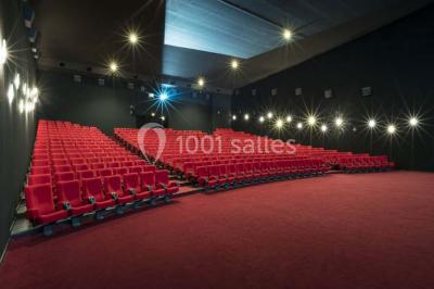 Façade d'un cinéma Pathé avec affiches de films en vitrine, sous un ciel bleu clair.