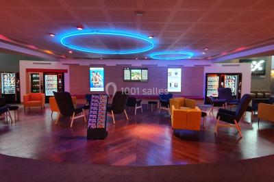 Façade d'un cinéma Pathé avec affiches de films en vitrine, sous un ciel bleu clair.