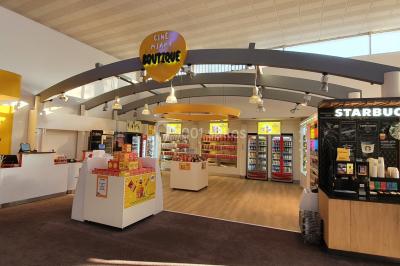 Façade d'un cinéma Pathé avec affiches de films en vitrine, sous un ciel bleu clair.