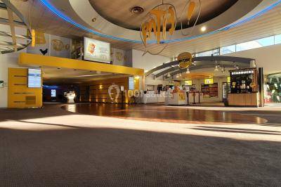 Façade d'un cinéma Pathé avec affiches de films en vitrine, sous un ciel bleu clair.