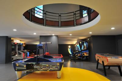 Rangées de sièges rouges alignés dans une salle de cinéma vide, éclairée par une lumière tamisée.