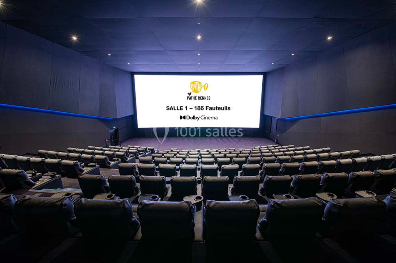 Salle de cinéma moderne avec sièges inclinables, écran géant affichant des informations sur la salle et le système Dolby…