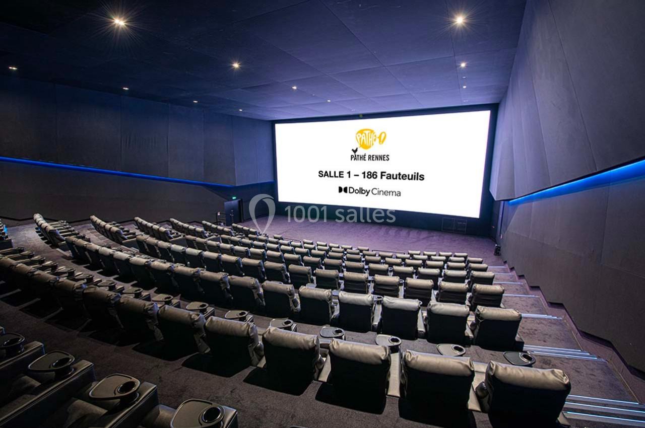 Salle de cinéma moderne avec fauteuils inclinables et grand écran affichant des informations sur la capacité et le format…