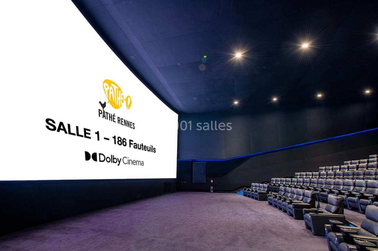 Salle de cinéma moderne avec écran géant, fauteuils inclinables et éclairage tamisé, affichant des informations sur l'écran.
