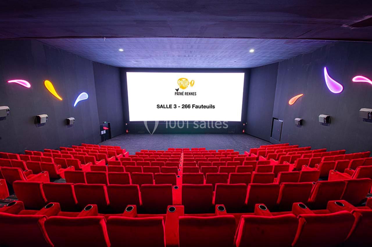 Salle de cinéma moderne avec rangées de fauteuils rouges et écran affichant ’Salle 3 - 266 Fauteuils’.