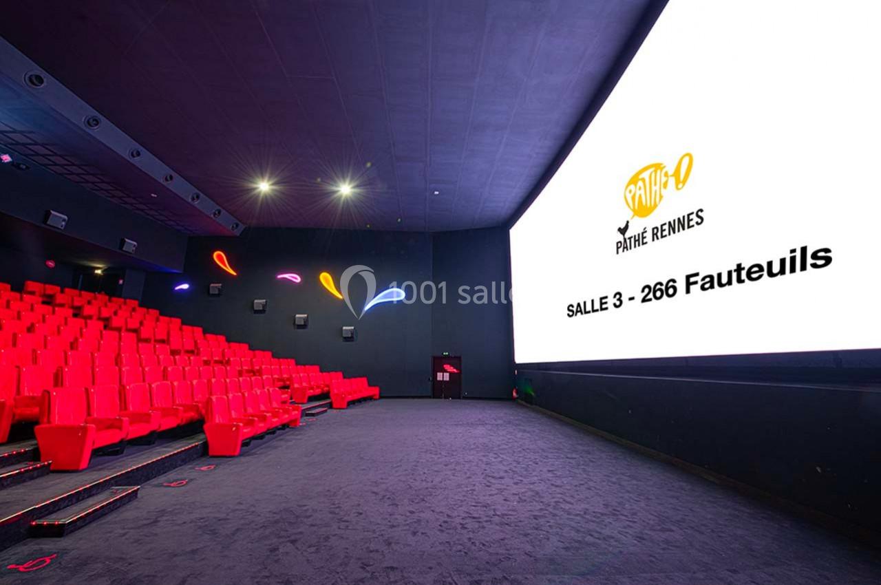 Salle de cinéma moderne avec rangées de sièges rouges et grand écran affichant ’Pathé Rennes, Salle 3 - 266 Fauteuils’.