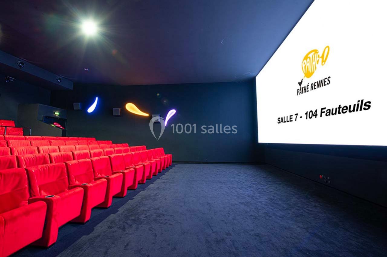 Salle de cinéma moderne avec fauteuils rouges, écran blanc affichant ’Pathé Rennes, Salle 7 - 104 fauteuils’.