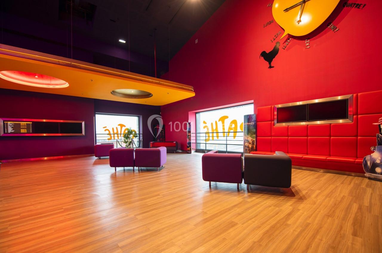 Salle moderne avec murs rouges, mobilier coloré, sol en bois clair et grande horloge murale décorative.