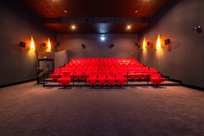 Entrée d'un cinéma Pathé avec affiches de films, sol violet, comptoirs de snacks et accès aux salles.