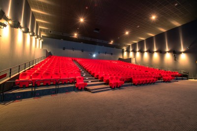 Entrée d'un cinéma Pathé avec affiches de films, sol violet, comptoirs de snacks et accès aux salles.