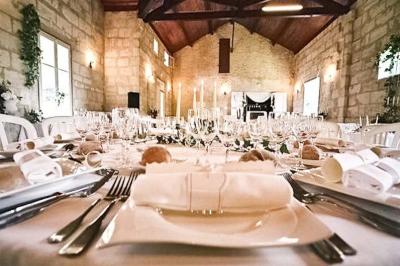 Cuisine vide avec carrelage beige, évier mural, étagères blanches, réfrigérateur et porte au fond.