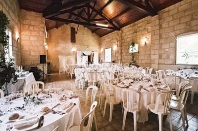 Cuisine vide avec carrelage beige, évier mural, étagères blanches, réfrigérateur et porte au fond.