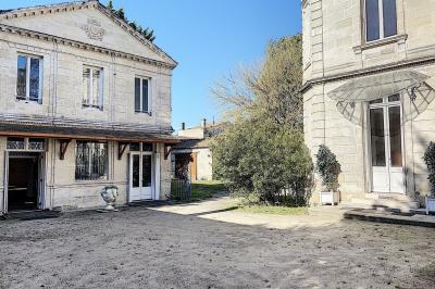 Cuisine vide avec carrelage beige, évier mural, étagères blanches, réfrigérateur et porte au fond.