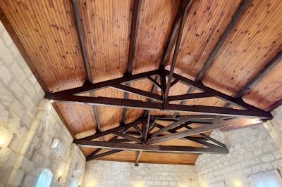 Cuisine vide avec carrelage beige, évier mural, étagères blanches, réfrigérateur et porte au fond.