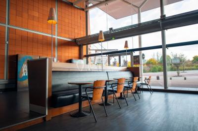 Salle de cinéma vide avec fauteuils rouges, grand écran allumé et plafond illuminé par des motifs lumineux.