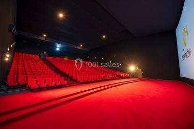 Hall spacieux avec sol en marbre, comptoirs modernes, mezzanine jaune et éclairage suspendu.