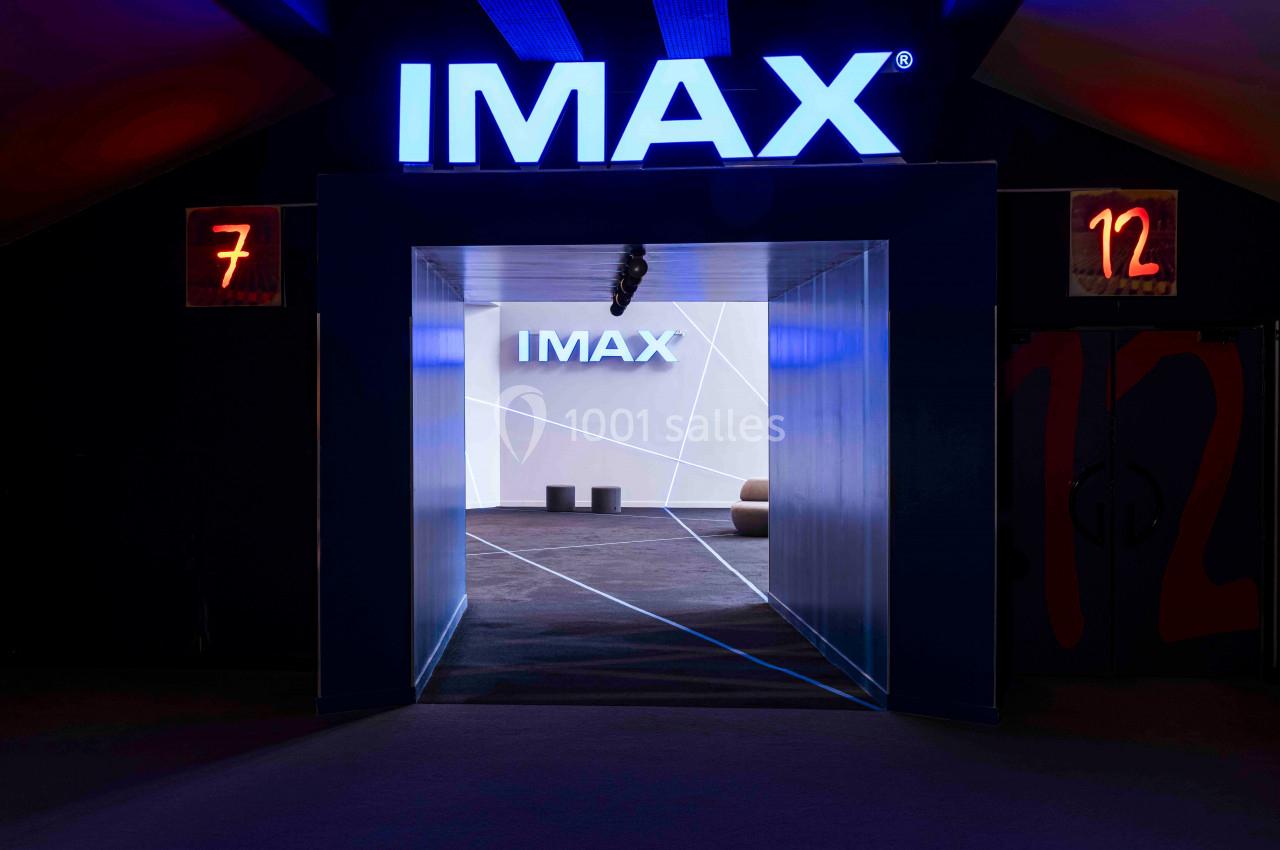 Entrée d'une salle IMAX avec signalétique lumineuse, murs sombres et numéros de salles 7 et 12 visibles.