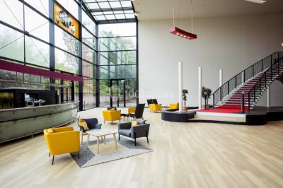 Salle de cinéma vide avec rangées de fauteuils rouges, éclairage tamisé et écran hors champ.
