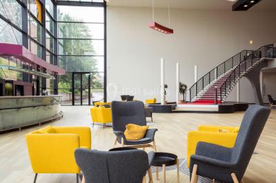 Salle de cinéma vide avec rangées de fauteuils rouges, éclairage tamisé et écran hors champ.