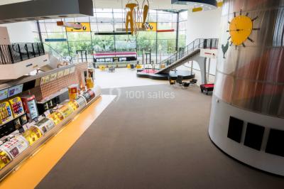 Salle de cinéma vide avec rangées de fauteuils rouges, éclairage tamisé et écran hors champ.