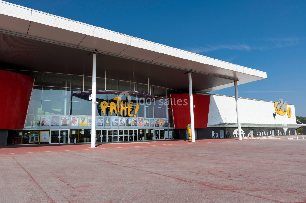 Façade d'un cinéma avec l'enseigne ’Pathé’, affiches de films visibles sur les vitrines et grand parvis devant.