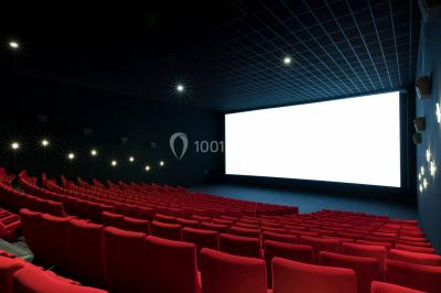Escalier mécanique dans un espace intérieur moderne avec moquette violette, plafonds hauts et enseignes lumineuses.