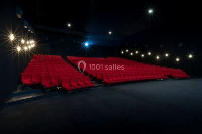 Escalier mécanique dans un espace intérieur moderne avec moquette violette, plafonds hauts et enseignes lumineuses.