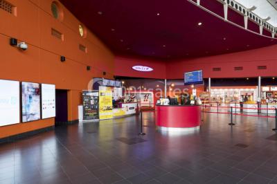 Salle de cinéma moderne avec sièges inclinables, éclairage tamisé et projecteur allumé.