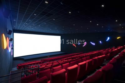 Salle de cinéma moderne avec sièges inclinables, éclairage tamisé et projecteur allumé.