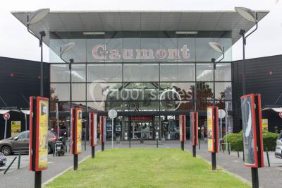 Salle de cinéma moderne avec sièges inclinables, éclairage tamisé et projecteur allumé.