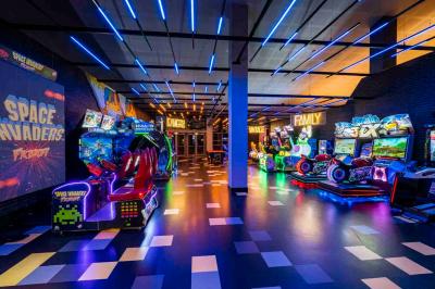 Façade d'un cinéma Pathé illuminée au crépuscule, avec des bâtiments en arrière-plan et des traînées lumineuses de voitures.