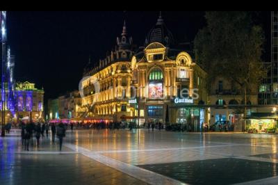 Façade d'un cinéma Gaumont avec des affiches de films et des parasols rouges devant l'entrée.