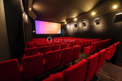 Façade d'un cinéma Gaumont avec des affiches de films et des parasols rouges devant l'entrée.