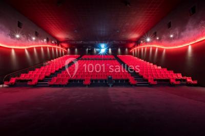 Deux fauteuils et une table basse dans un espace moderne avec un ascenseur encadré de lumière jaune au fond.