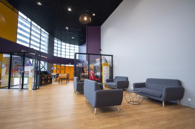 Salle de cinéma vide avec rangées de fauteuils rouges alignés face à un écran non visible.