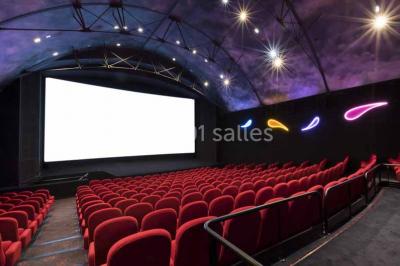 Miniature Location salle Nantes (Loire-Atlantique) - Pathé Nantes #8 Salle de cinéma vide avec des rangées de sièges rouges, un écran blanc et un plafond décoré d'étoiles.